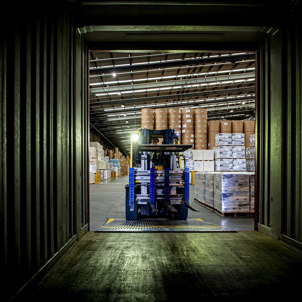 A Paper Hub Forklift unloading a shipping container at a UK Paper Hub Warehouse